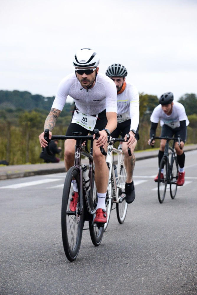 Tres ciclistas en fila con el dorsal a la vista