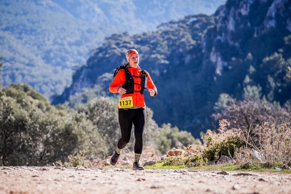 Corredora de trail con el dorsal 1137 entre montañas
